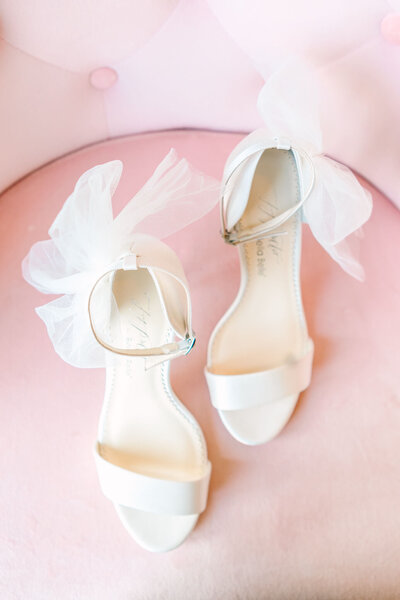 a bride gazes at her wedding bouquet with cream and peach flowers