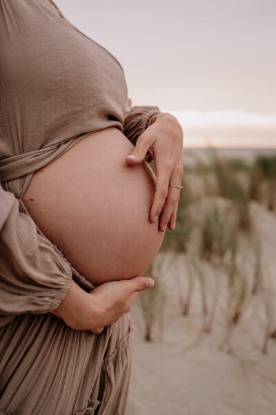 Close up foto van zwangere vrouw op het strand
