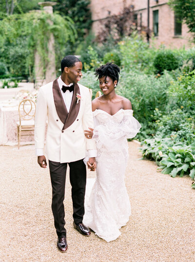Bride and groom walk down garden path at their wedding at the Swan House in Atlanta