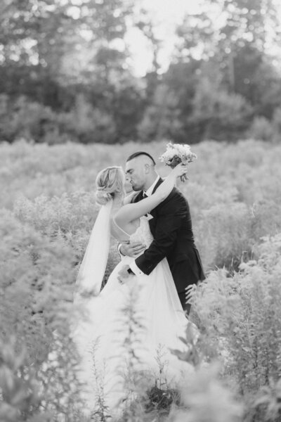 bride and groom kissing in the middle of the field at Mill of Kintail in Almonte, Ontario. Photographed by Ottawa and Destination Wedding Photographer, Brittany Navin Photography