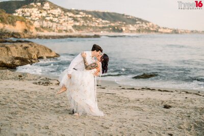 Bride to be kiss her Groom on the cheek during engagement session at Treasure Island Beach in Laguna Beach
