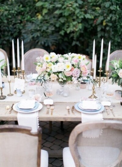 close up of wedding table design with florals and tapered candles