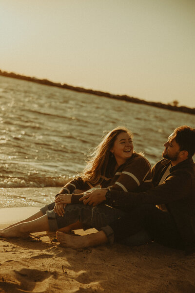 Man and woman romantically spin around, laughing in the middle of a  flowery field
