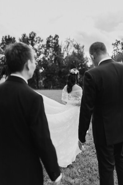 groomsmen carrying bridal gown