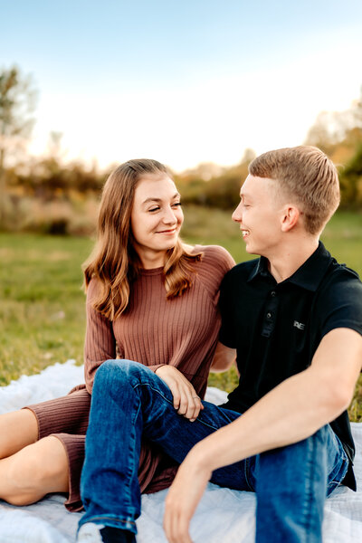 Delaware Ohio Couple stare lovingly at each other while sitting on blanket in grass