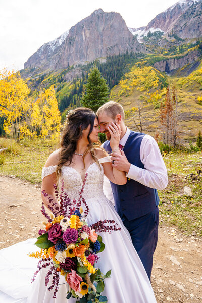 Bride and groom posing among fall aspens with mountain views during their wedding in Crested Butte, Colorado.