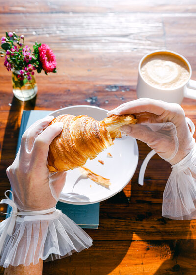 Creative colorful product photography for bakery pastry shop. Hands grabbing pastries croissant with ruffled gloves fashion