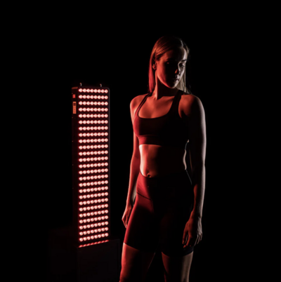 Person standing in front of a full body light panel with red light