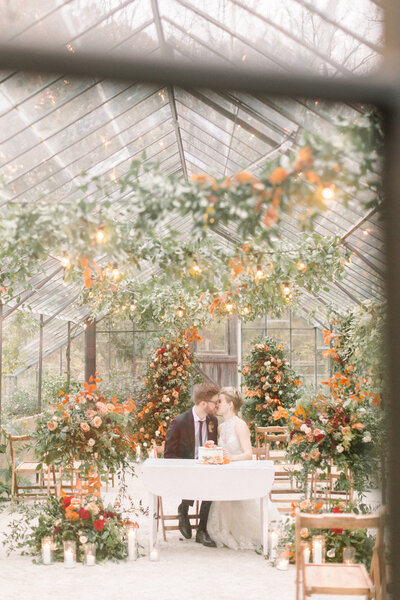 wedding couple kissing under arch with wedding flowers in indiana