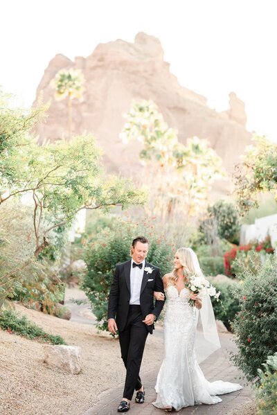 Bride and Groom walking down a path at the Sanctuary Resort in Scottsdale Arizona with Camelback mountain ion background
