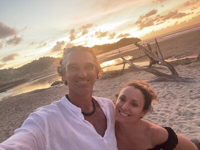 Alicia and Errin, co-founders of EnForma, smiling together at sunset on Sayulita Beach in Mexico—embodying their shared passion for wellness, nature, and intentional living.