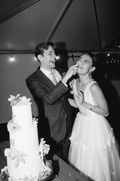 groom feeds bride wedding cake