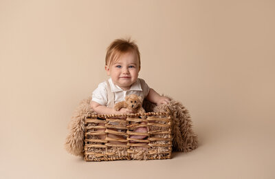 baby in basket holding teddy bear by Philadelphia Newborn Photographer