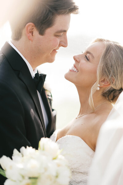 A brunette groom leans in to his blonde bride's face as they embrace each other on their wedding day. Captured by Jackson MS wedding photographer Jessica Greene Photography.