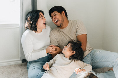 Parents laugh with each other as they play with their kids during a family photoshoot with Cassey Golden.