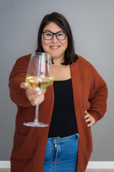 Woman holding out a glass of white wine