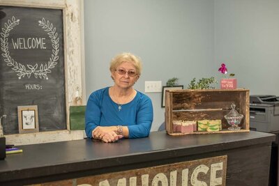 An older woman standing behind a counter