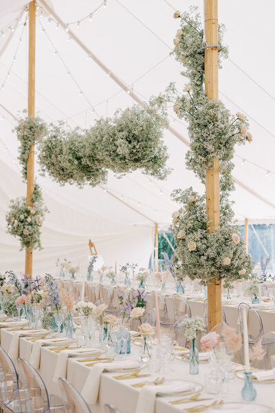 Tented wedding reception with greenery and pastel color palette