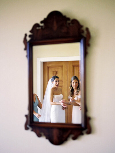 A brides photo through a mirror as she is getting ready in Goodstone Inn in Middleburg, Va.