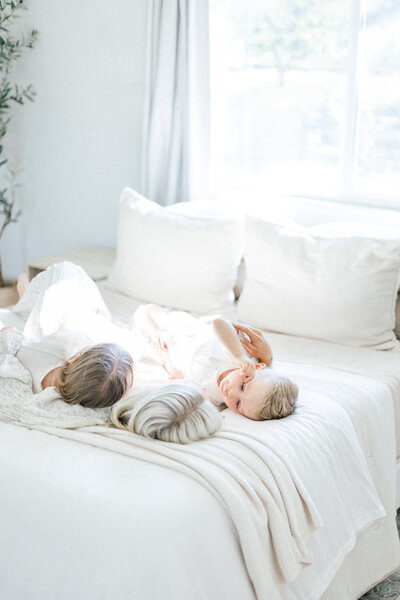 Image of mother and children lying on bed in home taken by Family Photographer Sacramento Kelsey Krall