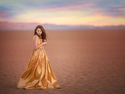 Girl in gold dress at red lake.