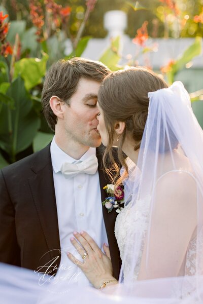 Couple kissing with flowers in the background