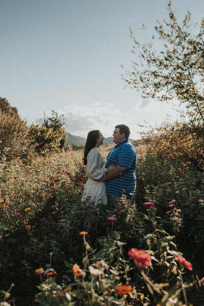 wildflower field engagement session by Knoxville photographer  with couples holding each other in a wildlfower field with mountains in the distance 