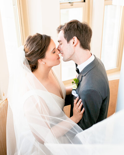 Newlyweds kiss in the stairwell during their wedding at the Branford House in Groton, CT.