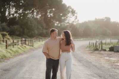 A couple walking down a dusty road  photographed by Tashina Narelle Photography & Videgraphy in Auckland