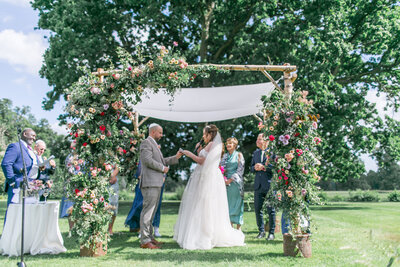 Bride and Groom saying their vows under the chuppah in an outdoor ceremony at Ditton Manor