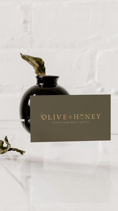 Olive and Honey business card in front of a black jar