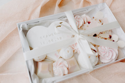 bow tied box with a full size heart shaped sugar cookie, chocolate shards, truffles, and meringues