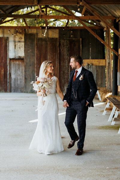 Couple Walking under barn at Silchester Farm on their wedding day