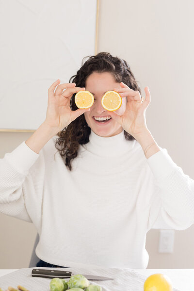 Grace playfully holding lemons in front of her eyes