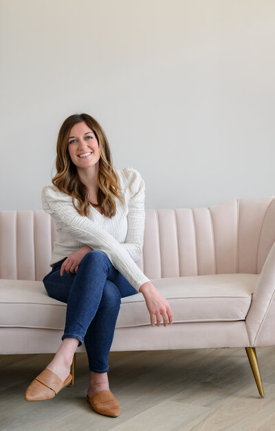 A woman sitting on a couch with her legs crossed