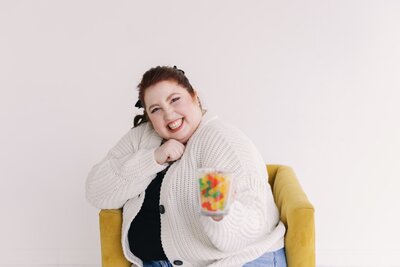 woman holding gummy bears and smiling