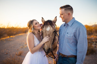 Jess and Jon posing on their wedding day with their horse