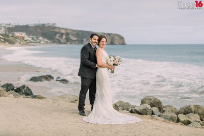 Engaged couple walk hand in hand along Salt Creek Beach during an engagement photo shoot