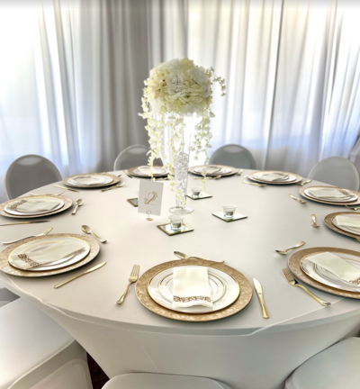 Stunning white reception guest table with gold accents and a grand floral centerpiece - A dream-worthy setup for your Clearwater wedding.