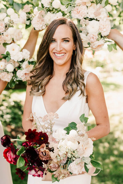 Brunette bride holding ethereal bouquet of flowers, surrounded by a floral crown. Captured by Seattle wedding photographer Luma Weddings