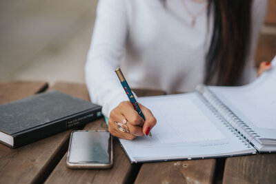 A woman writing in a journal. Showing one of the tools provided to you during eating disorder treatment. During your therapy an eating disorder therapist in Manhattan might suggest journaling.