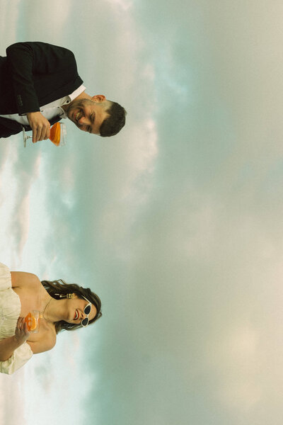 bride and groom kissing at the waters edge