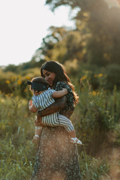 Family Photographer, Mother walking through field with baby on her hip
