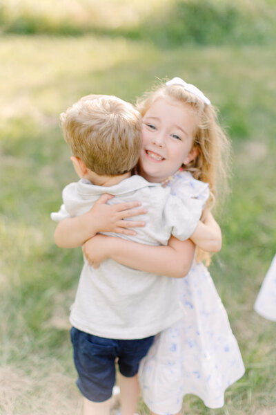 A young brother and sister are hugging during photo session with Boston family photographer Corinne Isabelle