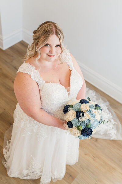 A bride looking up while holding a bouquet of flowers.