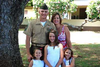 Marine and his wife and 3 daughters pose for family photo