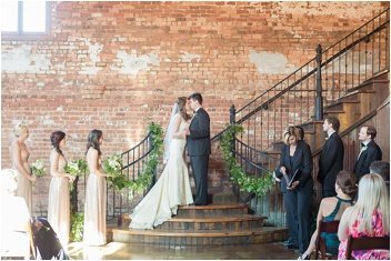 wedding ceremony first kiss at the Old Cigar Warehouse in Greenville