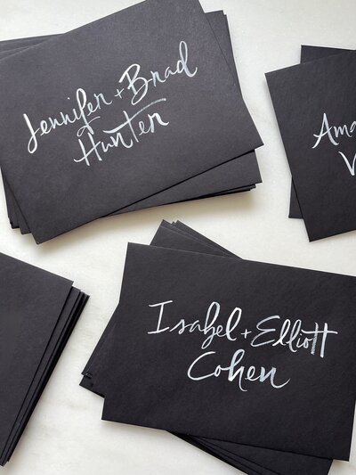 Black envelopes with white white brush lettering