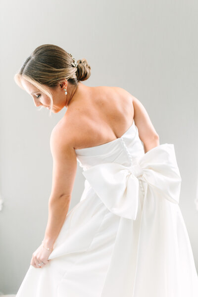 Bride wears wedding gown with large bow