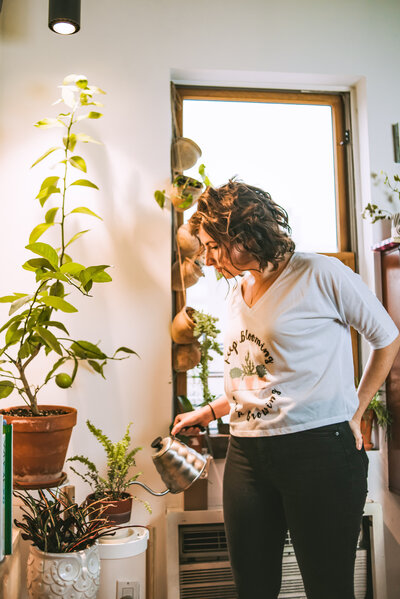 Woman waters her indoor houseplants